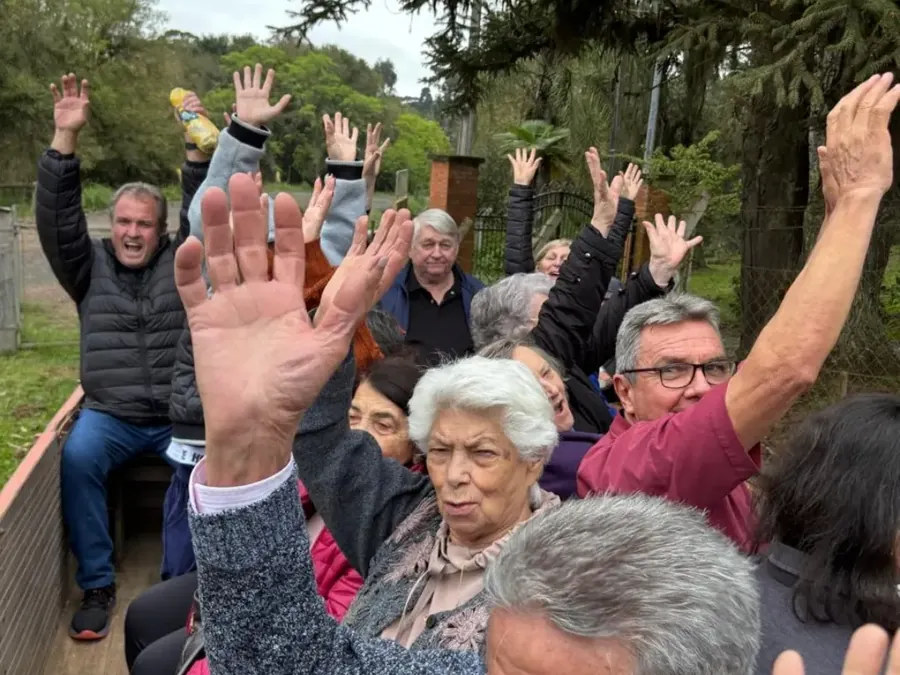 Grupo animado de braços erguidos durante passeio